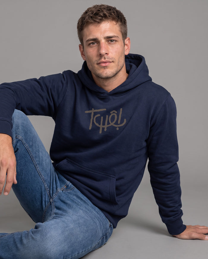 Homem sentado no chão vestindo o Hoodie Tchê! Clássico na cor marinho